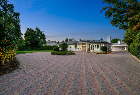 Wide paver driveway with trimmed lawn